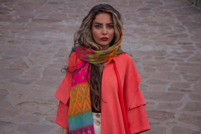 woman in red coat standing on white sand during daytime