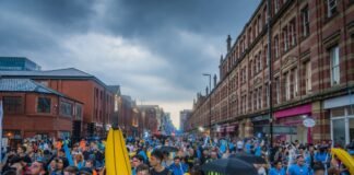 Manchester City recupera el liderato de la Premier League en la recta final de la temporada a large group of people walking down a street