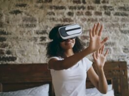 La revolución de los asistentes virtuales localizados: cuando la inteligencia artificial aprende español Young woman wearing vr headset, reaching out hands.