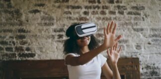 La revolución de los asistentes virtuales localizados: cuando la inteligencia artificial aprende español Young woman wearing vr headset, reaching out hands.