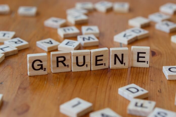 A wooden table topped with scrabble tiles spelling the word grune