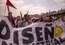 Los desafíos de la integración laboral para jóvenes migrantes: entre la supervivencia y la esperanza group of people holding Disen text tarpaulin