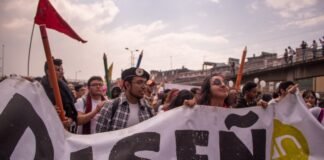 Los desafíos de la integración laboral para jóvenes migrantes: entre la supervivencia y la esperanza group of people holding Disen text tarpaulin