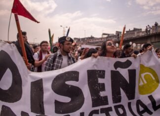 Los desafíos de la integración laboral para jóvenes migrantes: entre la supervivencia y la esperanza group of people holding Disen text tarpaulin
