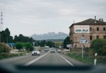 Los combustibles en España superan la barrera psicológica de 1,70 euros mientras el diésel marca el ritmo alcista a street with cars driving down it and a building in the background