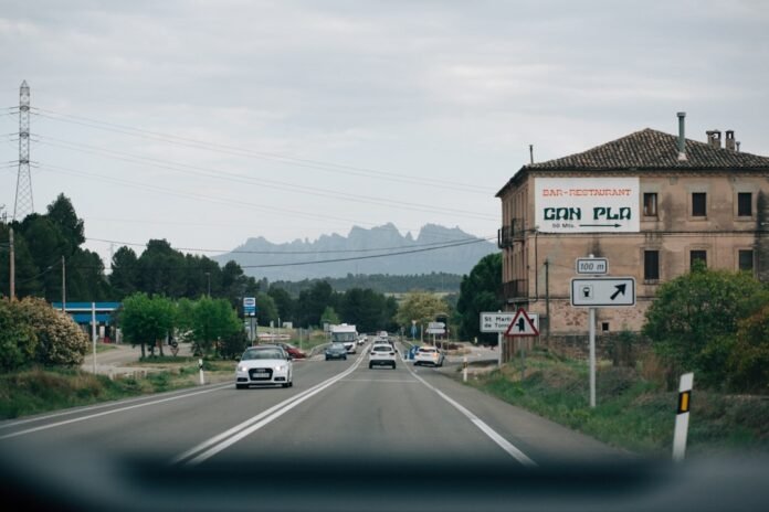 a street with cars driving down it and a building in the background