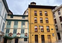 El desafío del Real Oviedo: Cuando David se enfrenta a Goliat en La Cartuja Colorful old buildings with flowers on balconies.