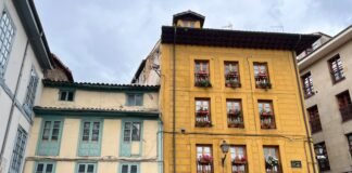 El desafío del Real Oviedo: Cuando David se enfrenta a Goliat en La Cartuja Colorful old buildings with flowers on balconies.