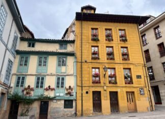 El desafío del Real Oviedo: Cuando David se enfrenta a Goliat en La Cartuja Colorful old buildings with flowers on balconies.