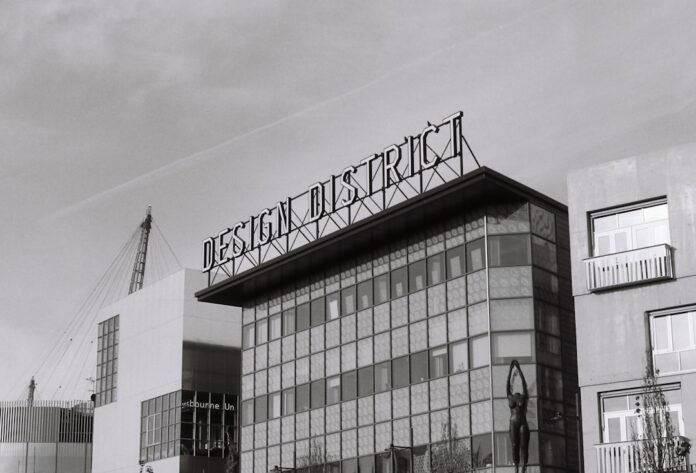 a black and white photo of a building with a sign on top