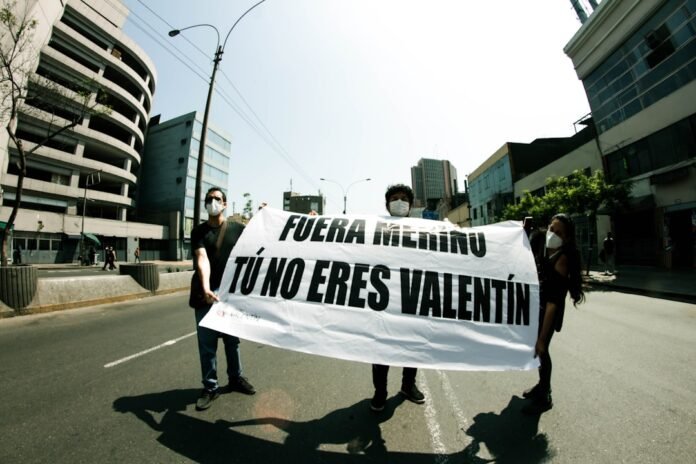 2 women holding white and black banner