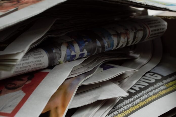 a bunch of newspapers stacked on top of each other