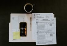 Los controles fiscales en operaciones de efectivo: qué necesitas saber en 2024 black Android smartphone near ballpoint pen, tax withholding certificate on top of white folder