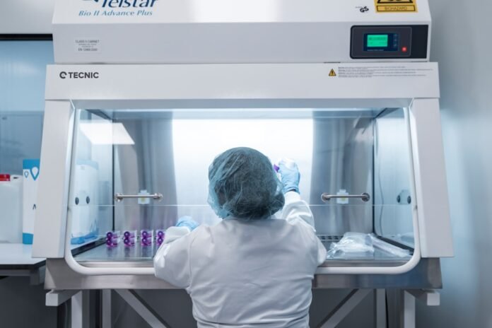 A scientist works in a lab hood, conducting research.