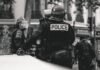 Controversia por agresión policial a manifestante en Valencia: cuando la fuerza pública traspasa los límites grayscale photo of Police standing and leaning on wall