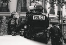 Controversia por agresión policial a manifestante en Valencia: cuando la fuerza pública traspasa los límites grayscale photo of Police standing and leaning on wall