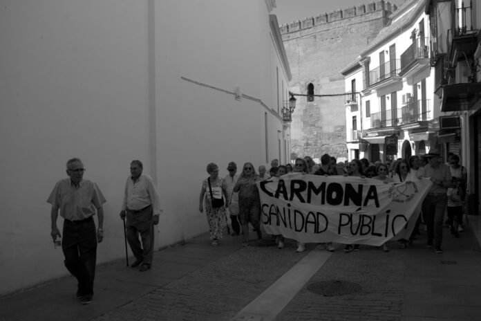 image_1781182829944 A group of people walking down a street holding a sign