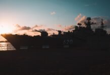 La revolución digital naval: cómo las nuevas tecnologías transforman la guerra marítima del siglo XXI Silhouette of a warship at sunset with dramatic clouds