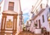 Descubre los secretos de los pueblos costeros andaluces: refugios perfectos para el verano español a building with a clock on the side of it