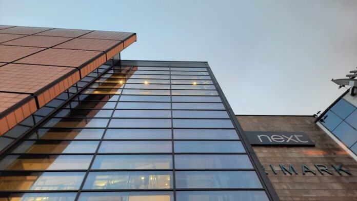 a tall glass building with a sky background