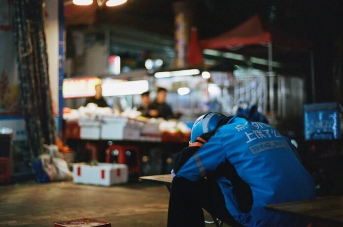 image_1783299635529 A delivery person takes a break in a busy street.