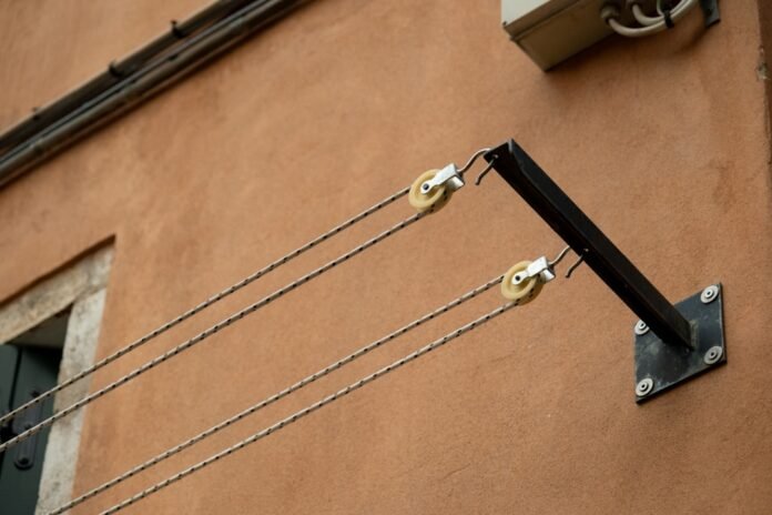 image_1784131236581 Clotheslines are on a terracotta wall.