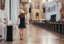 El turismo de interior conquista España: por qué los viajeros eligen la meseta y la montaña sobre la playa este verano Woman stands and looks at the church's interior.