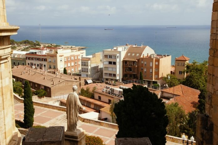 A view of a city with a statue in the foreground