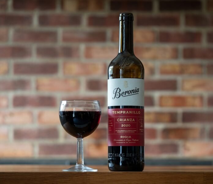 A bottle of wine and a glass on a table