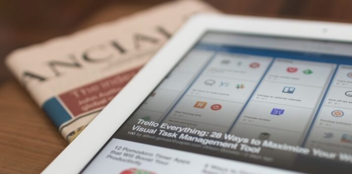 image_1785621637668 white tablet computer on top of newspaper