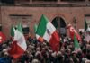 Italia vs España: La batalla por las fronteras de Schengen que sacude los cimientos de Europa A large group of people holding flags in front of a building