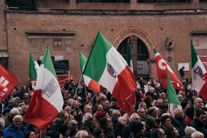 A large group of people holding flags in front of a building