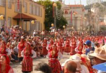 El Festival Internacional de Folclore de Almería cumple 41 ediciones: un puente cultural que une tradiciones del mundo People in traditional costumes marching in a street parade.