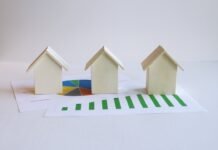 Mercado Inmobiliario en España 2026: El Auge de las Provincias Interiores Frente a la Caída Nacional de Compraventas three small houses sitting on top of a piece of paper