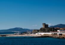 Baterías portátiles de nueva generación: cómo la tecnología de carga rápida está transformando nuestra autonomía digital Coastal town with historic tower overlooking the sea.