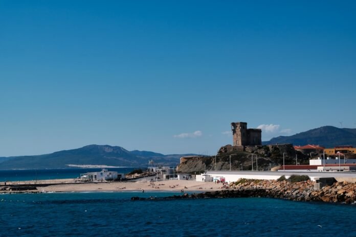 Coastal town with historic tower overlooking the sea.