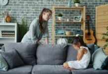 Violencia en espacios de ocio público: cuando las piscinas municipales se convierten en escenarios de tensión extrema Mother scolds crying daughter on sofa in living room.