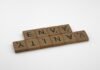 Entre palabras y barras: el retrato de las creadoras migrantes que construyen identidad lejos de casa a scrabbled wooden block spelling the word envy