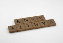 Entre palabras y barras: el retrato de las creadoras migrantes que construyen identidad lejos de casa a scrabbled wooden block spelling the word envy