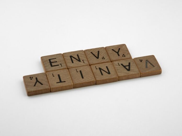 a scrabbled wooden block spelling the word envy