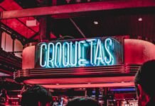 El Origen de las Grandes Fortunas: Por Qué la Creación de Riqueza Es Más Compleja de lo que Pensamos group of people gather outside bar
