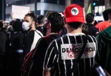 La Democracia Liberal en Crisis: Cuando las Instituciones Fallan más Rápido que las Soluciones a group of people standing around each other wearing face masks