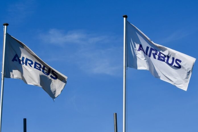 Two airbus flags waving against a clear blue sky