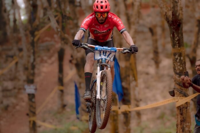 A man riding a bike through a forest