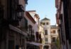 Sevilla conquista el paladar internacional: la cultura del tapeo sevillano que enamora al mundo A narrow city street with a clock tower in the background
