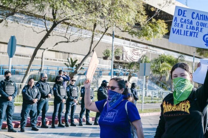 a woman holding a sign in front of a group of people