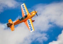 Repsol apuesta por el viento de Estados Unidos: estrategia renovable en tiempos de cambio político a small orange airplane flying through a cloudy blue sky