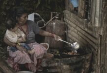 Nepal bajo las aguas: la tragedia de las inundaciones y la búsqueda desesperada de ciudadanos españoles desaparecidos woman cooking while cuddling a child