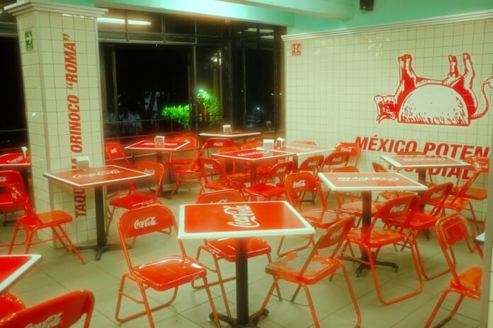 Empty restaurant interior with red tables and chairs at night