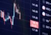 Estrategias de inversión en Bolsa para el último trimestre: sectores con mayor potencial de revalorización A digital financial candlestick chart showing market trends on a dark screen